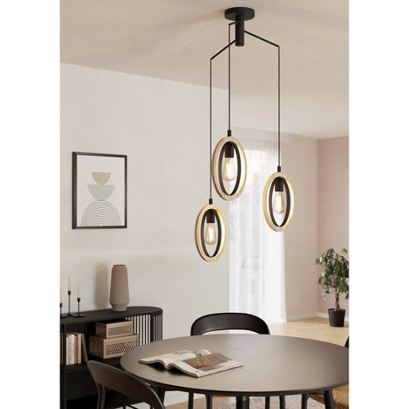 Rolmanne 3 Light Pendant in black steel and wood, with three oval rings on staggered cords holding exposed E27 bulbs, shown above a round dining table.