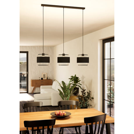Ronarne Fabric Linear Pendant Light in black, three drum shades with diamond-mesh tiers on a long bar, shown above a wooden dining table.