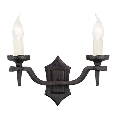 The Rectory 2 Light Wall Light - Black is a rustic wall sconce featuring two candle-shaped bulbs on a wrought iron holder. It showcases a medieval design with ornate details, and its antique black finish stands out beautifully against the white background, adding a vintage touch.