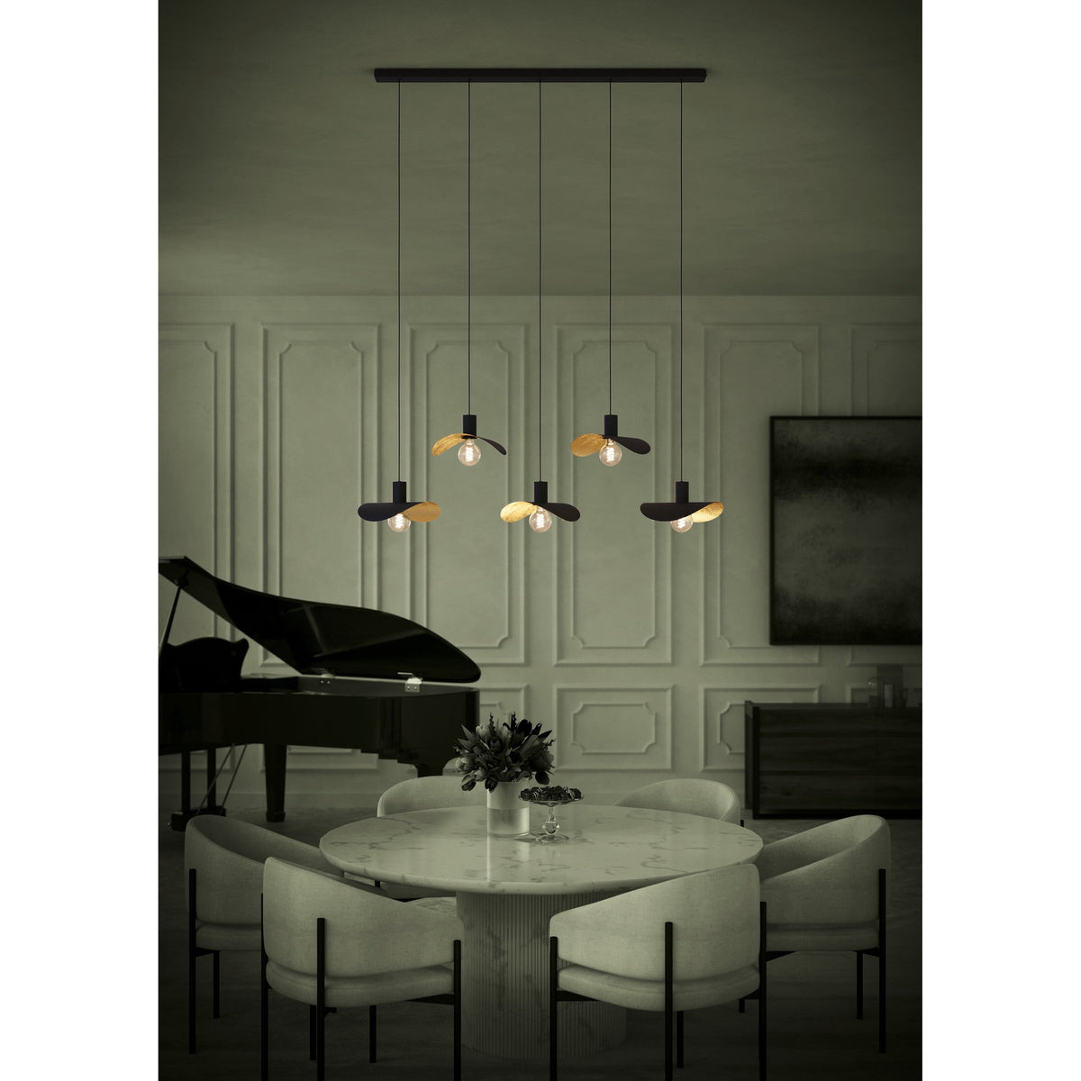 Saceda Linear Pendant Light in black and gold, five staggered hat-shaped shades with gold leaf undersides on a black bar, shown above a dining table.