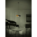 Saceda Pendant Light 53cm in black and gold steel, single curved disc shade over a bulb, hung above a dining table in a panelled room.