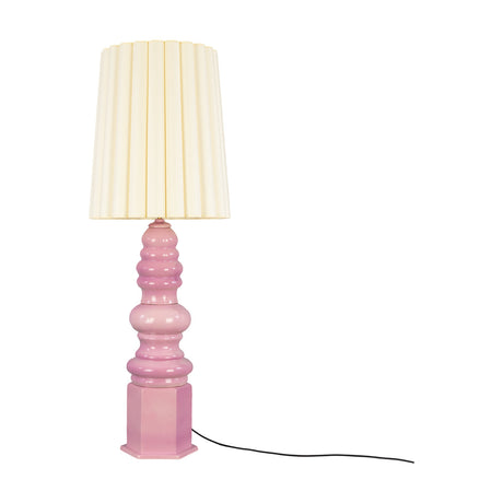 Safi Ceramic Table Lamp with a tiered Carnation Pink glossy base on a hexagonal plinth, paired with a tall pleated cream fabric shade, shown on a white background.