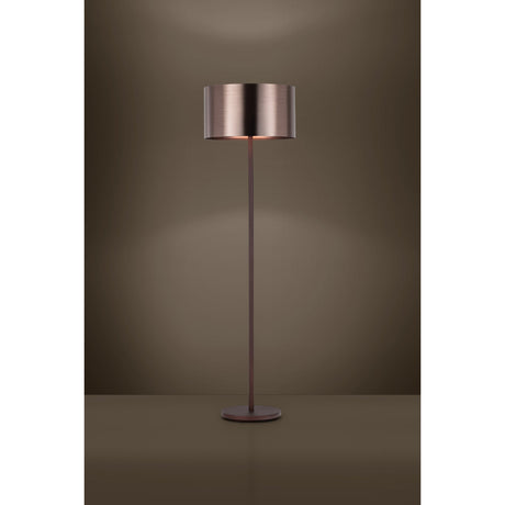 Saganto 1 Floor Lamp in brown, featuring a wide drum shade in brushed brown-copper metallic finish atop a slim steel stem and round base, set against a dark neutral background.