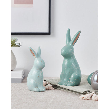 Saidane ceramic rabbit ornaments in light green with speckled glaze and pink-toned ears, shown in two sizes on a shelf beside books and a small vase.