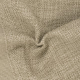 Sanchore Placemat in beige, close-up of the woven cotton fabric gathered to show its textured basket-weave pattern and speckled natural tones.