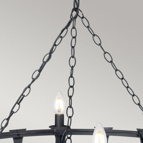 A close-up of the Saxon 8 Light Chandelier - Black presents its decorative chain and candle-style bulbs situated against a light gray background. The lit bulbs emphasize the chandelier’s timeless, medieval design.