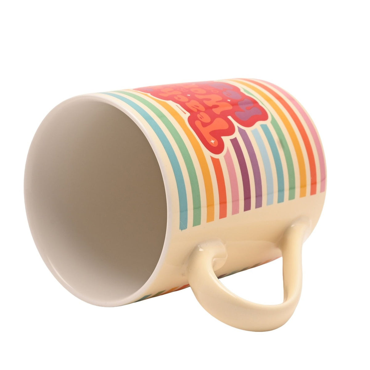 Porcelain mug tipped on its side showing the plain cream interior, curved handle and rainbow stripe exterior with "Teaching is a work of heart" on a red badge, plain white background.