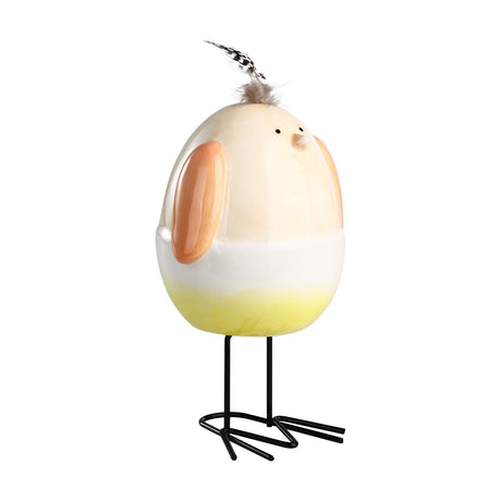 Sendayan Bird Ornament, an egg-shaped ceramic figurine with high-gloss pastel apricot top, white band and yellow base, apricot wings, feather crest and thin black metal legs, on a white background.