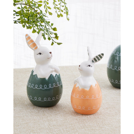 Sendayan Ceramic Rabbit Ornament in orange, white and green, a figurine of a rabbit emerging from a cracked egg with a striped ear, shown beside a matching green version on a textured tabletop.