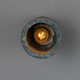 Senna Ceramic Ceiling Light in Blue Earth glaze, round cylinder shade with dark mottled blue-green finish, brass canopy, glowing E27 bulb visible inside, shown against a plain grey background.