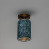 Senna Ceramic Ceiling Light in Blue Earth glaze, a cylindrical ceramic shade with crackled texture on a round brass ceiling canopy, shown against a plain grey background.