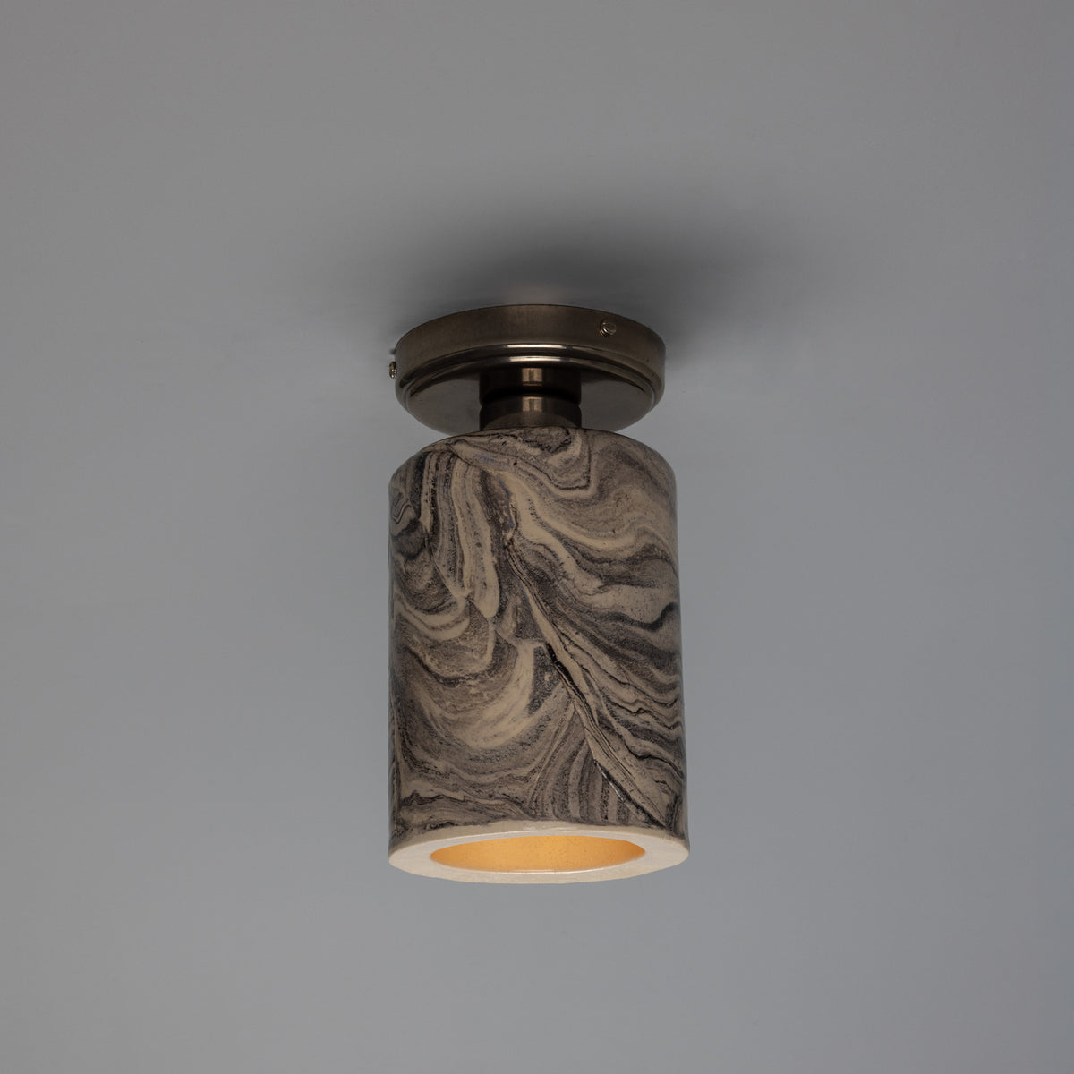 Senna Ceramic Ceiling Light with a slim cylindrical shade in marbled grey and cream glaze, fixed beneath a round dark metal canopy, shown against a plain grey background.