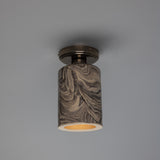 Senna Ceramic Ceiling Light with a slim cylindrical shade in marbled grey and cream glaze, fixed beneath a round dark metal canopy, shown against a plain grey background.