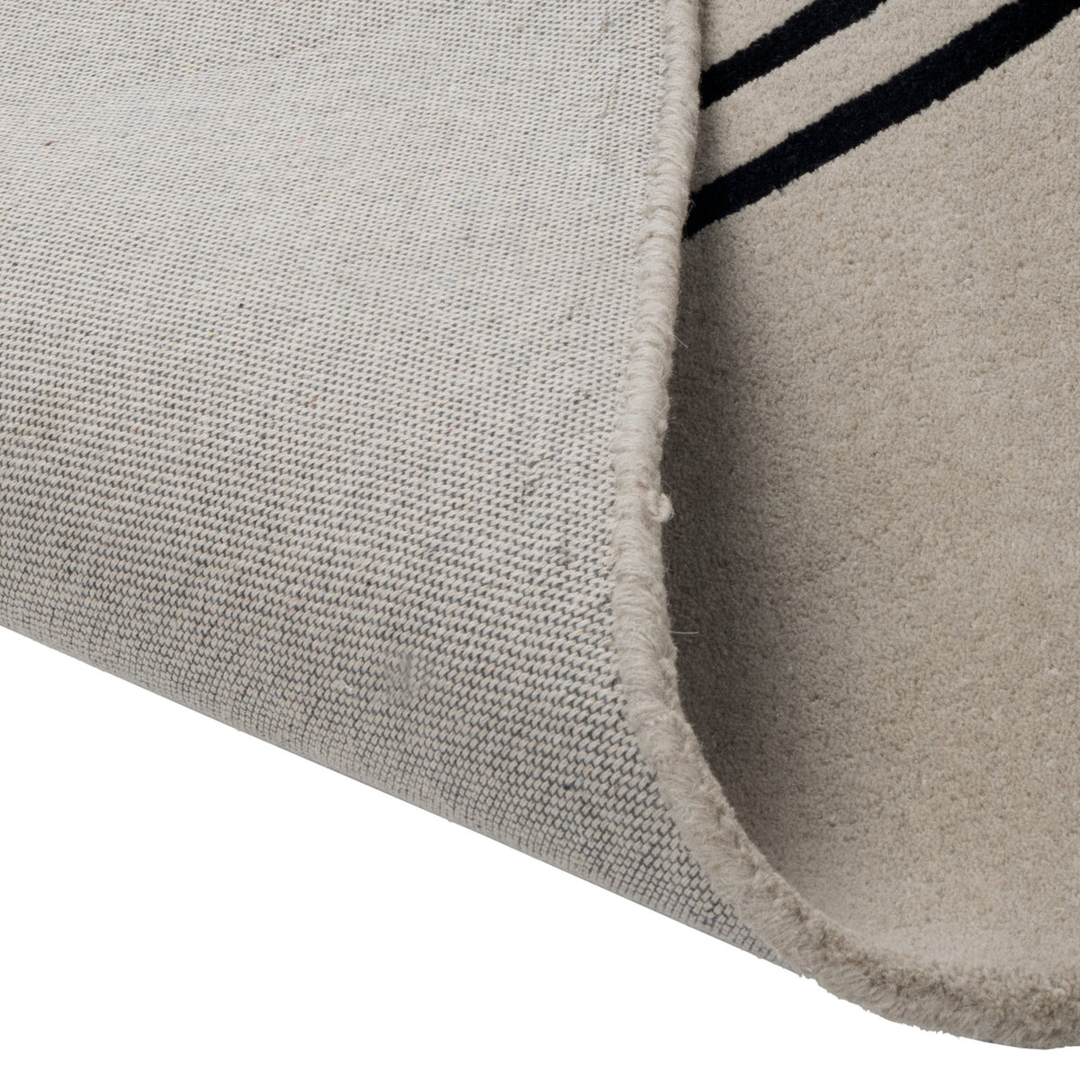 Sesulu Circle Pattern Rug 300 x 200cm, corner folded back to show beige pile and woven backing with black stripe pattern visible along the edge.