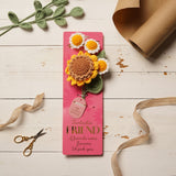 Crochet flower bundle on pink "Fantastic Friend" card, featuring one brown-centred yellow sunflower and three white-and-yellow daisies with green leaves, displayed on a wooden surface.