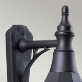 Close-up of the Shannon 1 Light Outdoor Down Wall Light in black, showcasing its decorative design with a smooth, matte finish. This corrosion-proof fixture features a curved arm and an ornate top detail. Its IP44 rating guarantees durability against the elements, set against a plain, light gray background.