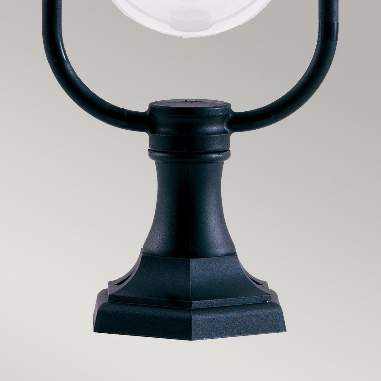 Close-up of the Shannon 1 Light Pedestal in black, featuring an elegant, curved design and a square foundation against a neutral background. The partial view of the globe-shaped lamp at the top highlights its IP44 rating for corrosion-proof durability.