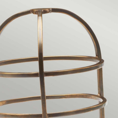 Close-up of a Cage Accessory for Sheldon & Somerton in Brass, featuring intersecting metal bars forming rounded shapes. This elegant lantern piece is set against a neutral, light gray background.