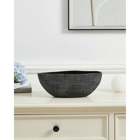 Shiguhe ceramic decorative bowl with an oval shape and wavy rim, black exterior with fine vertical silver ribs and a glossy black interior, shown on a sideboard beside décor.