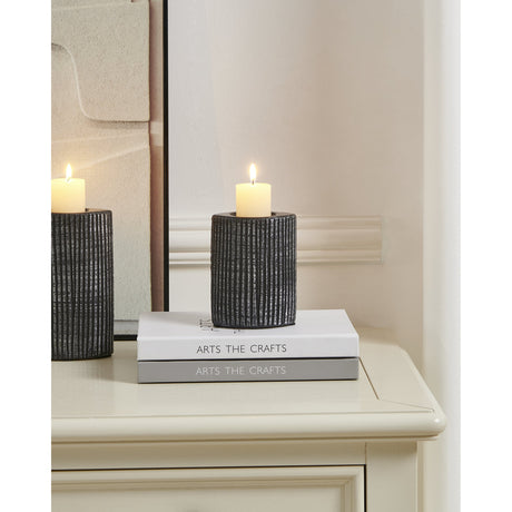 Shiguhe ceramic tealight holder, 12cm, with ribbed black and silver textured surface, holding a lit pillar candle on a bedside table beside a mirror.