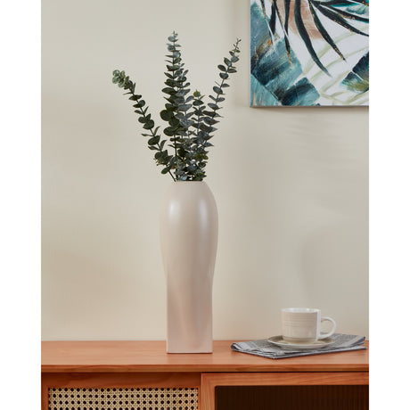 Shima Ceramic Vase in beige matt finish, tall tapering form with twisted lower body, styled with eucalyptus stems on a wooden sideboard.