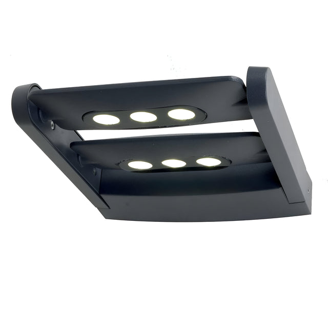 Introducing the Sigmund 6 Light Outdoor Wall Light - Graphite, a contemporary fixture featuring advanced LED technology with six circular bulbs arranged in two rows. Its sleek, rectangular design and curved cover deliver stylish illumination, making it an ideal choice for modern exteriors. Additionally, its IP65 rating guarantees durability against harsh weather conditions.