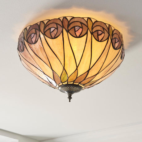 Tiffany Pentleigh medium 2-light flush ceiling light with domed leaded glass shade in multicoloured rose motifs and aged metal fitting on a white ceiling.