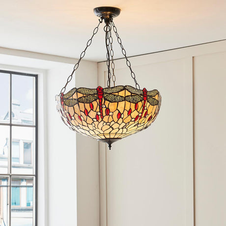 Alderworth Large 3 Light Tiffany inverted pendant in beige leaded glass with dragonfly motif, suspended on chains in a bright room by a window.