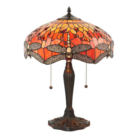 Alderworth Medium Tiffany table lamp with a flame amber leaded glass shade featuring a dragonfly motif on a turned brass-finish metal base.
