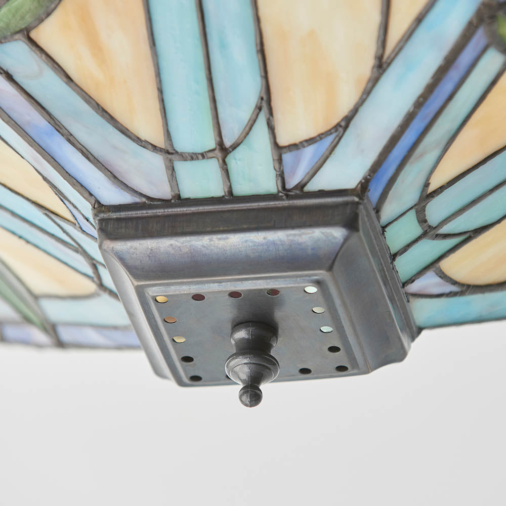 Close-up of the Tiffany Thornmere Medium 2 Light flush ceiling light's square metal mounting plate and leaded multicoloured glass shade in blue and cream tones.