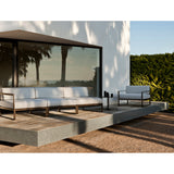 Sit Aluminium Modular Garden Sofa with left arm module and cream cushions, shown on an outdoor terrace with bronze-finished aluminium sled-leg frame.
