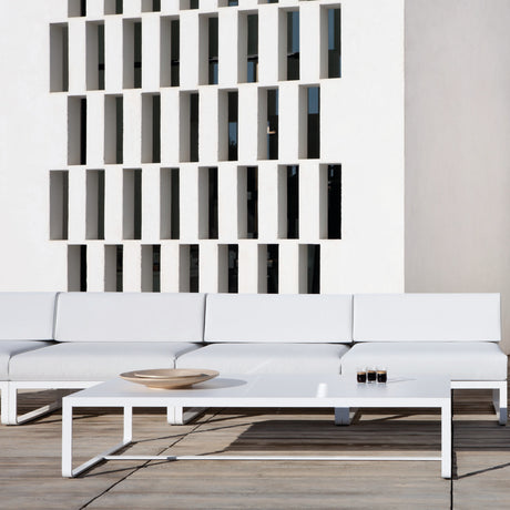 Sit Aluminium Outdoor Coffee Table in white, 120 x 80cm, rectangular with sled-style legs, shown on a terrace beside a white outdoor sofa.