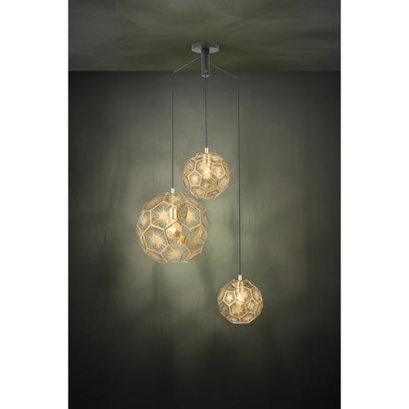 Skoura 3 Light Pendant in black and brass, three staggered faceted globe shades with open pentagon and hexagon frames on black cables from a round black ceiling canopy, shown lit against a dark wall.