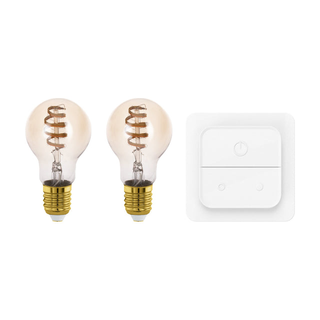 Two Smart LED GLS bulbs, E27, with amber-tinted glass and visible spiral filament, shown beside a white smart dimmer switch with push-button and dial controls on a plain white background.