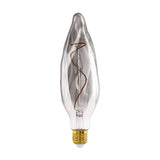 Smoked dimmable LED bulb with tall rippled flame-shaped glass, visible spiral filament and brass E27 screw cap, shown against a plain white background.