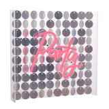 Party Neon Sign in pink script script mounted on a clear acrylic panel backed with round silver sequins, shown at an angle against a white background.