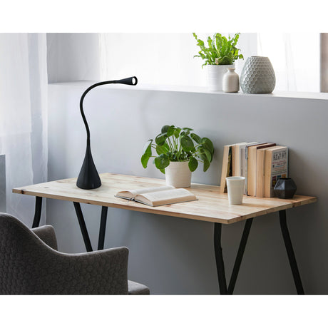 Snapora LED Touch Table Lamp in black with flexible gooseneck arm and flared cone base, shown on a wooden desk with books and a plant.