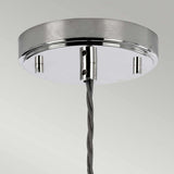 A modern Sola 1 Light Pendant in polished nickel with clear glass accents and a braided gray cable elegantly suspends against a light gray backdrop, showcasing its minimalist design.