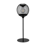 Solar LED table lamp in black steel with a round wire-mesh globe, built-in filament-style LED, solar panel on top, slim stem and round base, shown on a plain white background.