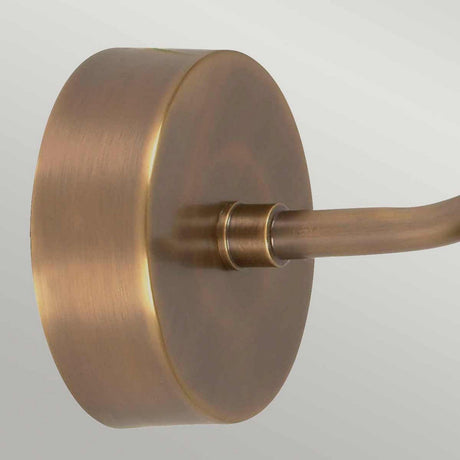 A close-up of the Somerton 1 Light Outdoor Wall Light in aged brass, featuring an extending arm. The smooth, metallic surface subtly reflects light, highlighting its warm tone and vintage design against a neutral background.