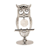 Chrome plated perched owl figurine with an open silver outline body, tufted ears, crystal eyes and a faceted hanging crystal, on a round pedestal base against a plain white background.