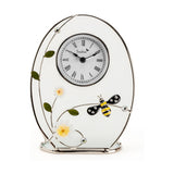Classic Oval Glass & Wire Bumble Bee Mantel Clock in white with a silver-tone frame, Roman numeral dial, daisy and bee accents, on a plain white background.