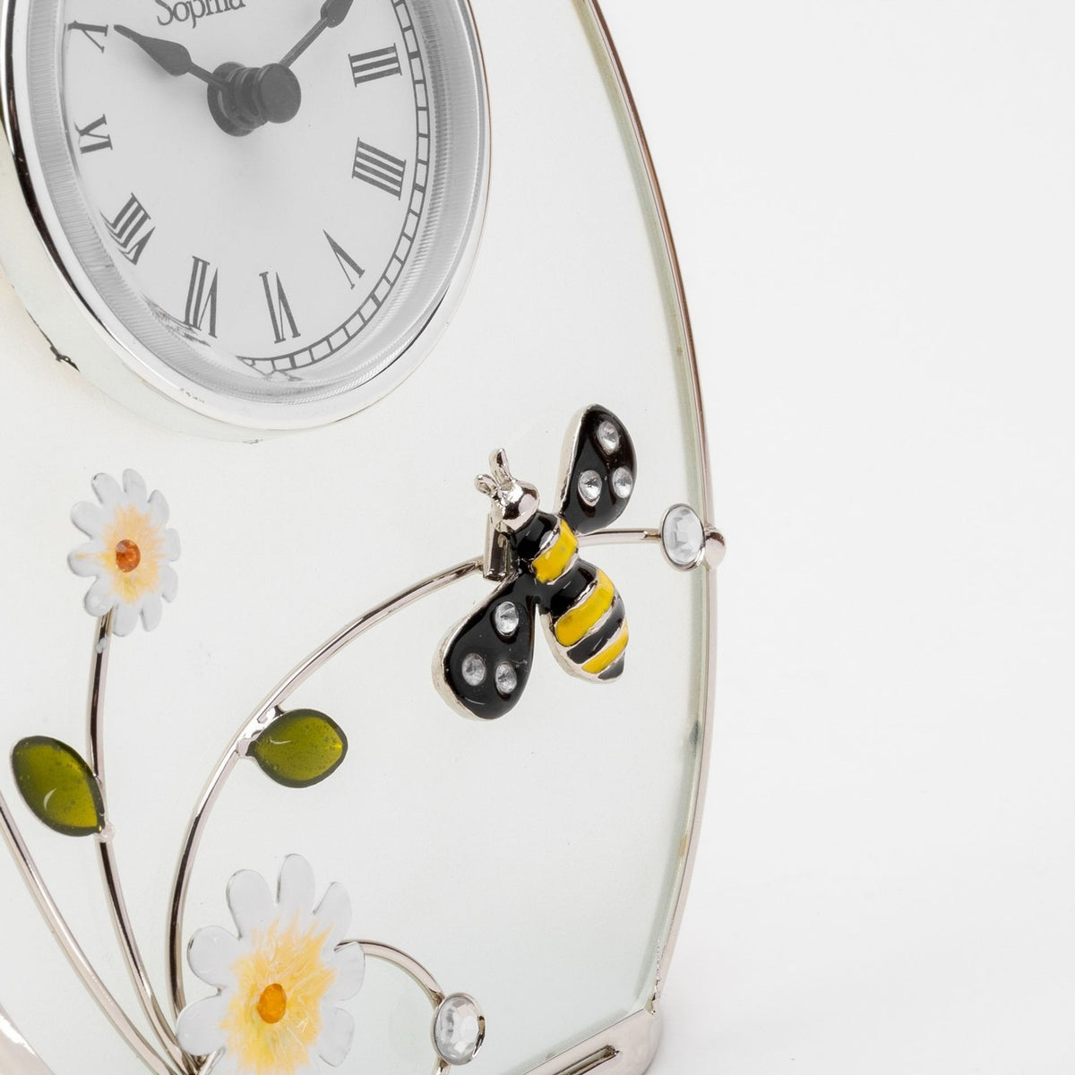 Close-up of the Classic Oval Glass & Wire Bumble Bee Mantel Clock in white, showing the enamelled bee, white flowers, and silver wire stems on the frosted glass panel.