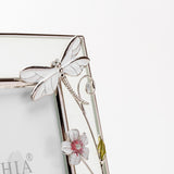 Close-up of the Classic Dragonfly Glass & Wire Photo Frame 6 x 4in in silver, showing a white hand-painted dragonfly and pink-centred flowers along silver wire on a pale glass border.
