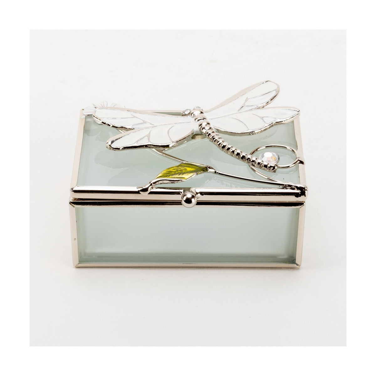 Rectangular frosted glass trinket box with silver-toned frame, white enamel dragonfly on the lid with wire stem, green leaf and pink-centred flower accent, shown on a plain white background.