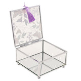Square glass trinket box with open lid printed with butterflies and floral sprigs, clear mirrored glass walls, silver-tone frame, and a purple tassel, shown on a white background.