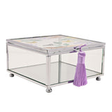 Square glass trinket box with silver-tone frame, clear glass walls, butterfly and floral printed lid, mirrored base, purple tassel, and ball feet, on a white background.