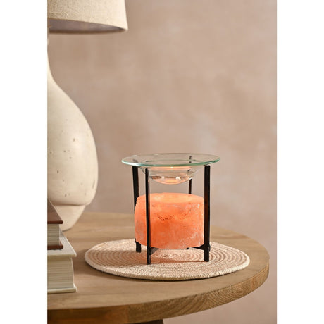 Small Himalayan Salt and Metal Wax Melt Burner in orange, with a rough-hewn salt block on a slim black metal stand and clear glass dish, shown on a side table.