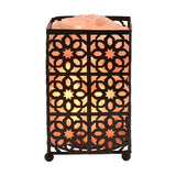 Moroccan style fretwork basket Himalayan salt lamp with black metal rectangular cage, star and petal cut-out pattern, pink salt chunks on top, glowing orange, on a white background.