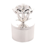 Round silver-coloured metal jewellery box with a plain polished base, topped by an open rose design holding a clear faceted jewel centre, shown on a white background.